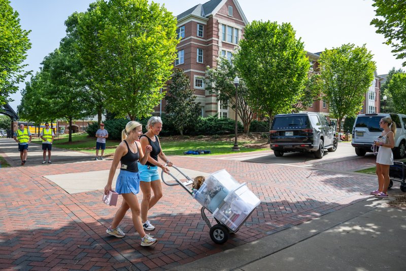 two female students rolling move in items
