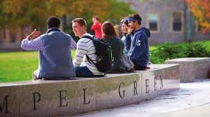 Students sitting on Tempel Green Stone Bench