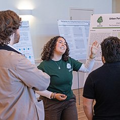 Photo of student presenting science research poster