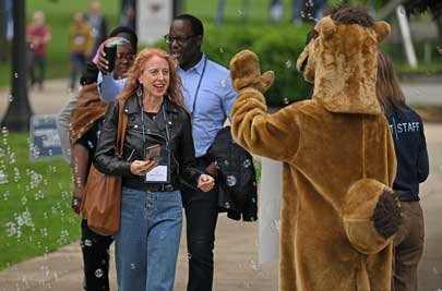 Photo of reunion attendee high fiving the camel mascot