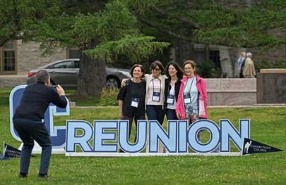 Photo of reunion attendees getting their picture taken with the CC Reunion sign