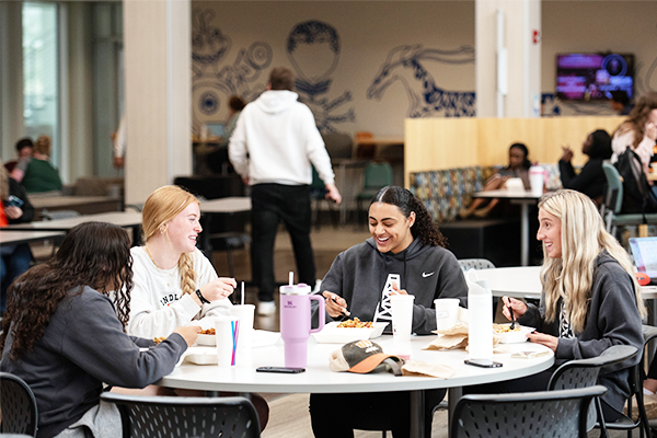 photo of four students eating at a round table