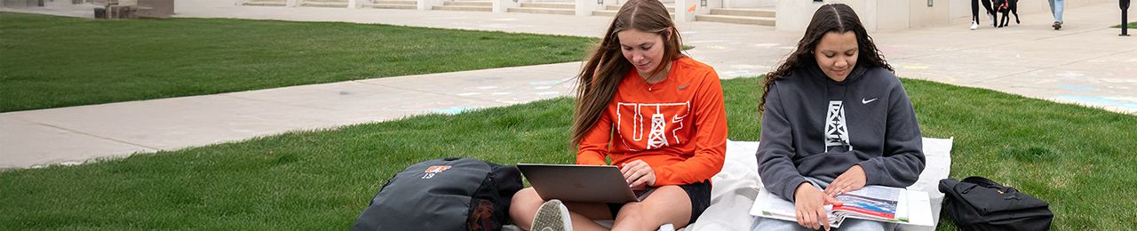 Two students studying in the grass