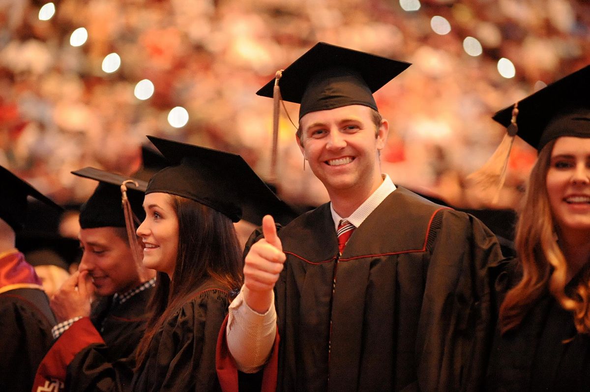 smiling graduate giving a thumbs up