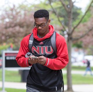 Student looking at their device on campus.