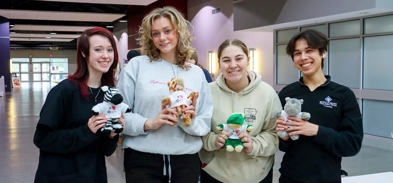 Photograph of four students smiling at the camera