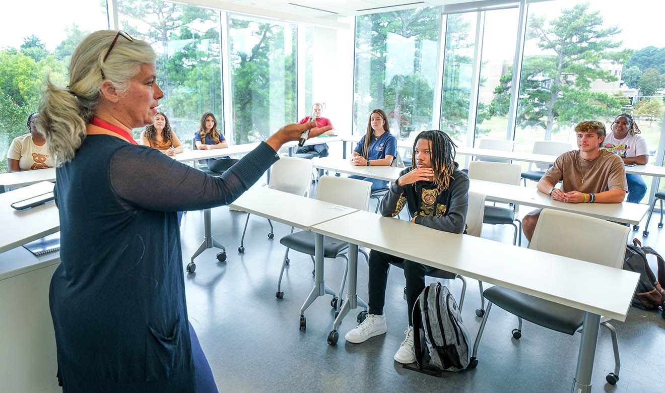 Photograph of a professor giving lecture to students in the classroom