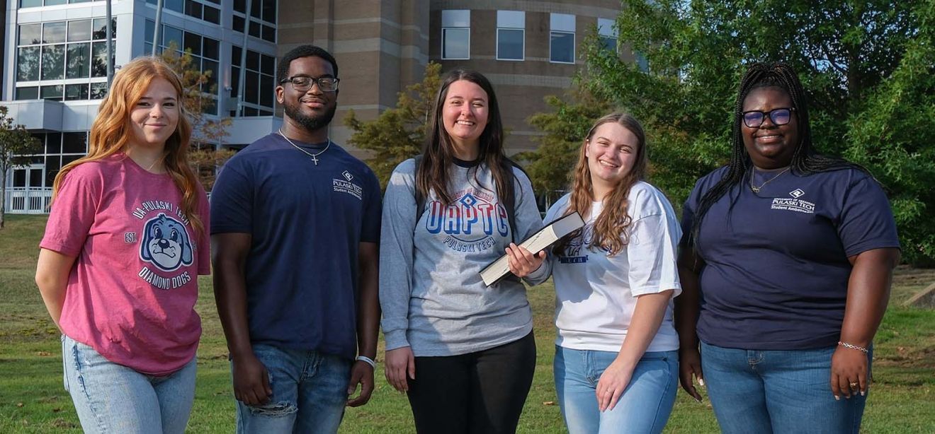 Photograph of five students smiling at the camera