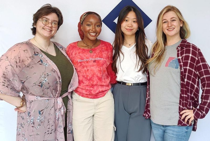 A group of four students smiling at the camera 