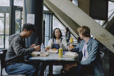 3 students eating at a table together