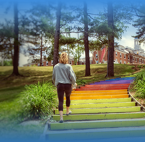 Student walks up rainbow steps at Tufts Medford campus