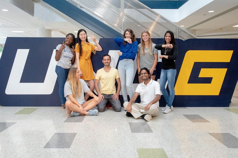 Students in front of UNCG letters