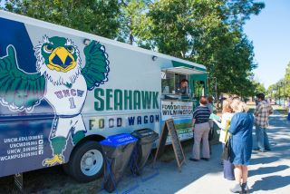 Image of a food truck with people lined up at the window