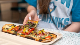 image of someone picking up a slice of flatbread pizza