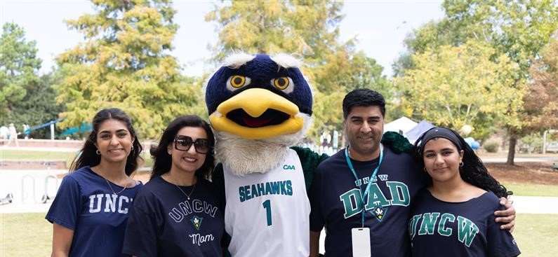 Group photo of a family with UNCW Sammy the Seahawk in the middle