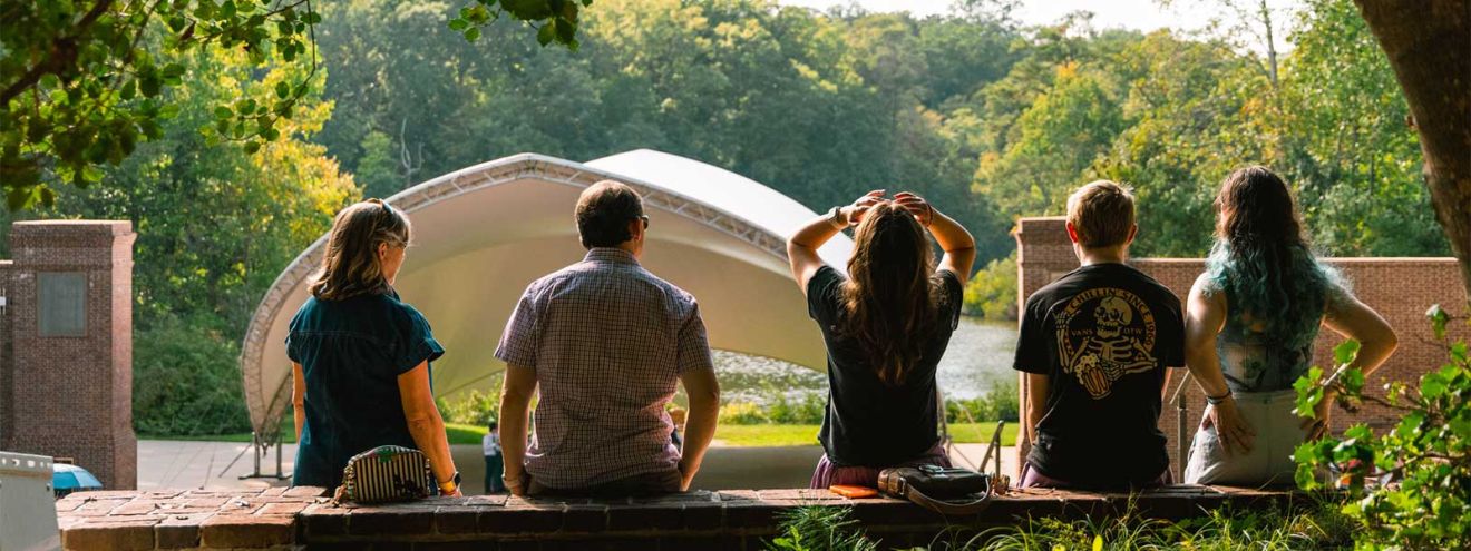 A family seated at the Martha Wren Briggs Amphitheatre at Lake Matoaka