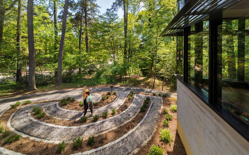 Curved walking path garden at the McLeod Tyler Wellness Center with two people walking along the path.