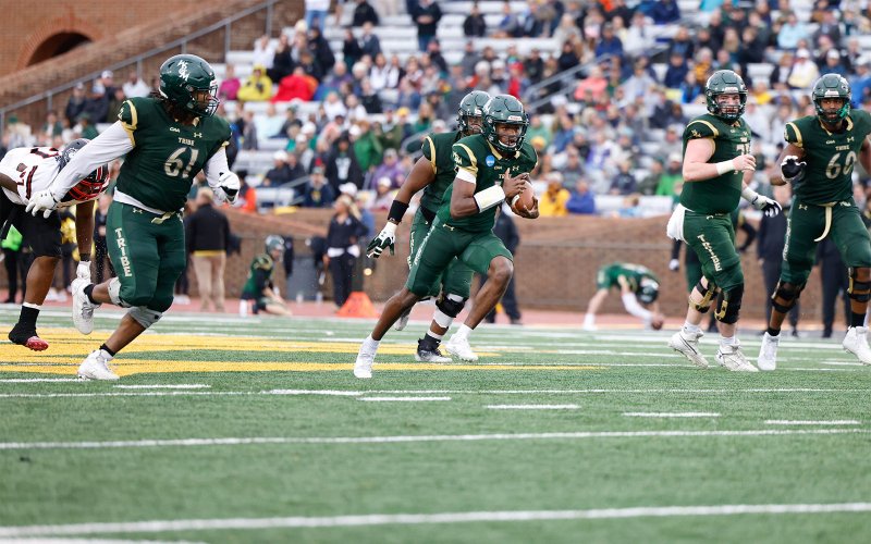 William & Mary football players running with the ball during a game at Zable Stadium.