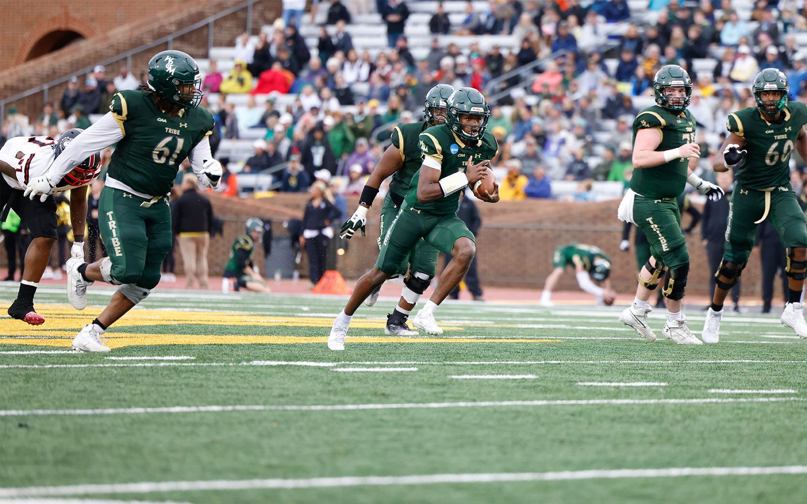 A William & Mary football player carrying a ball.